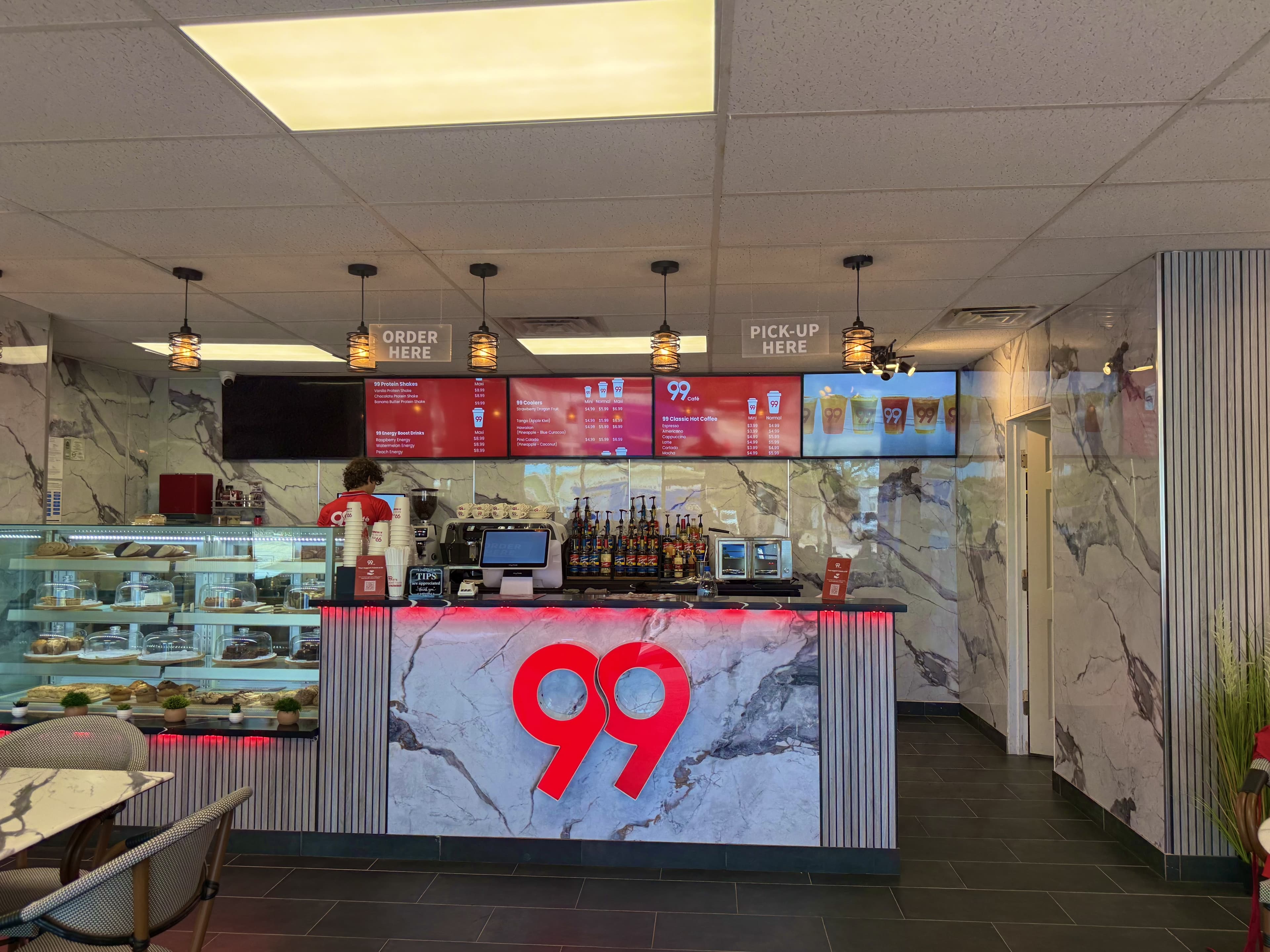 White marble architecture with large red 99 sign on the front coffee counter
