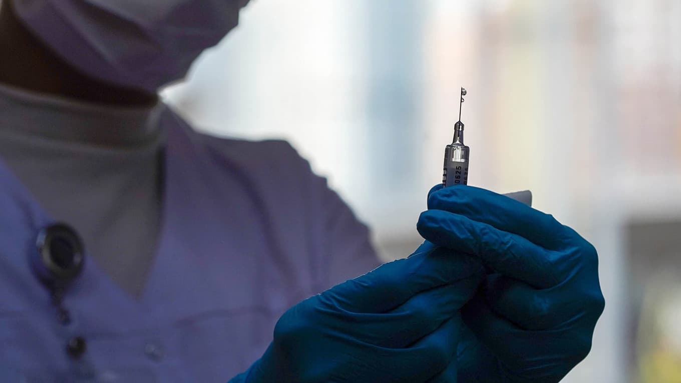 A doctor holding a needle
