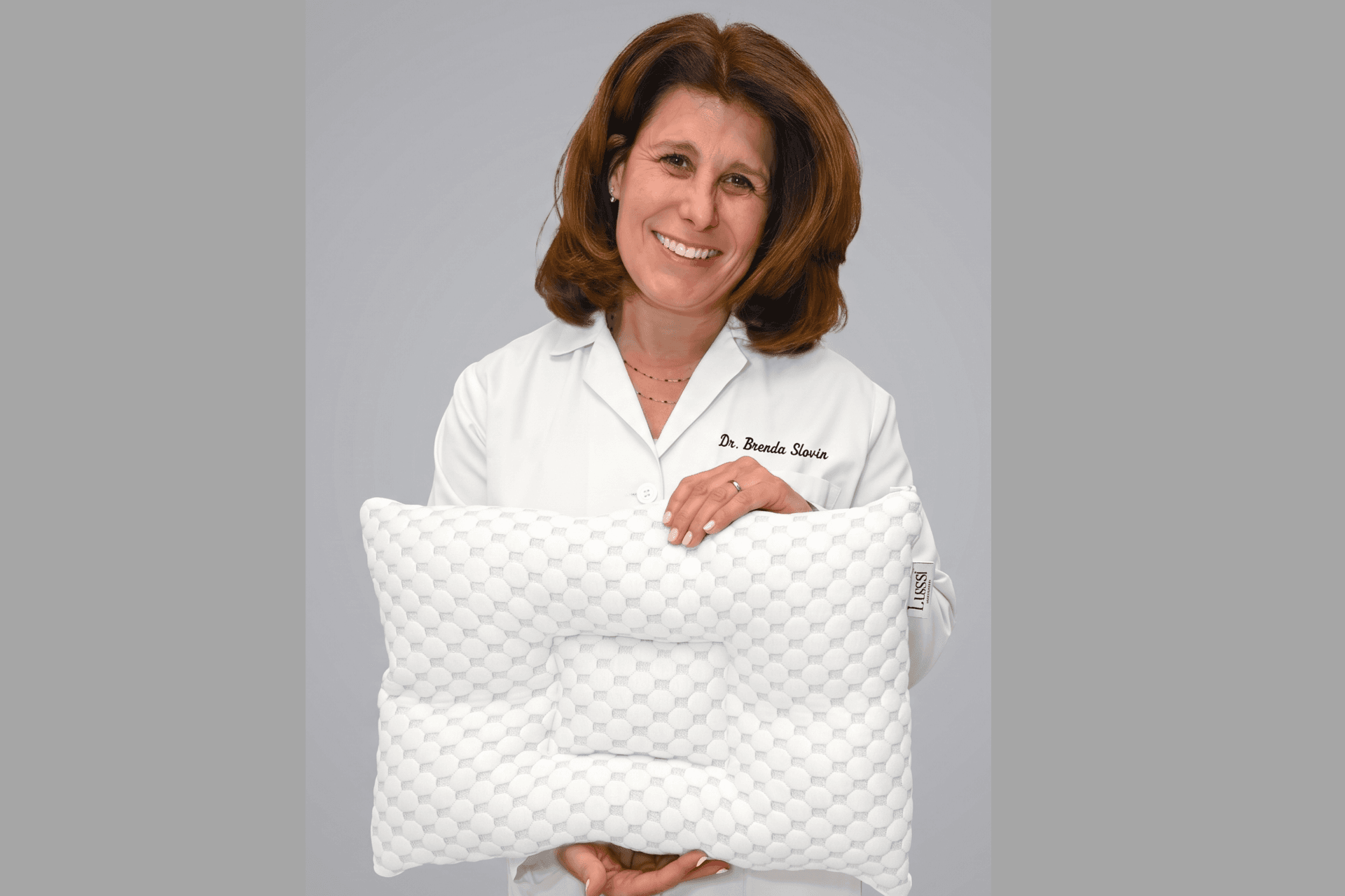 A women smiling holding a pillow